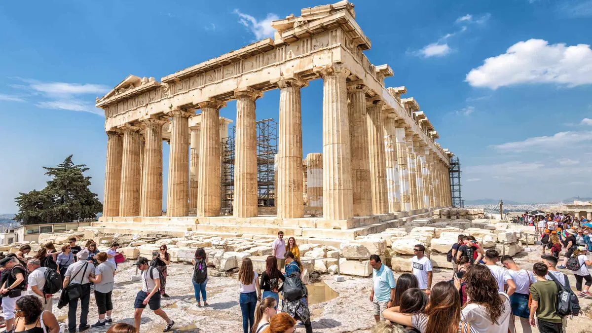 Visitors climbing the Propylaea steps on a pre-booked Acropolis entry ticket in Athens, Greece