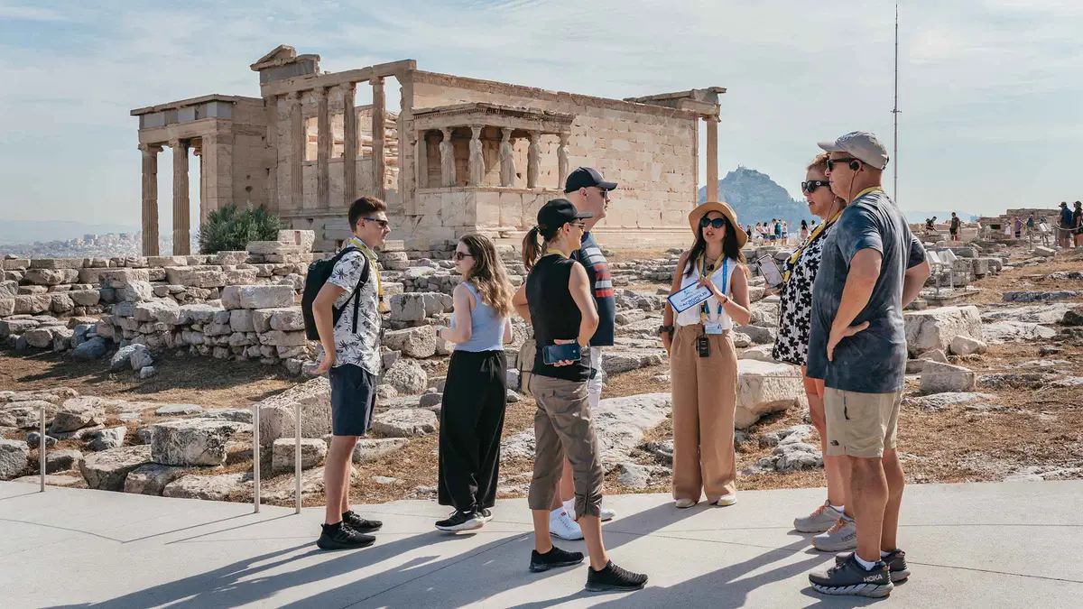 An archaeologist guiding visitors past the Parthenon frieze in the Acropolis Museum, Athens, Greece