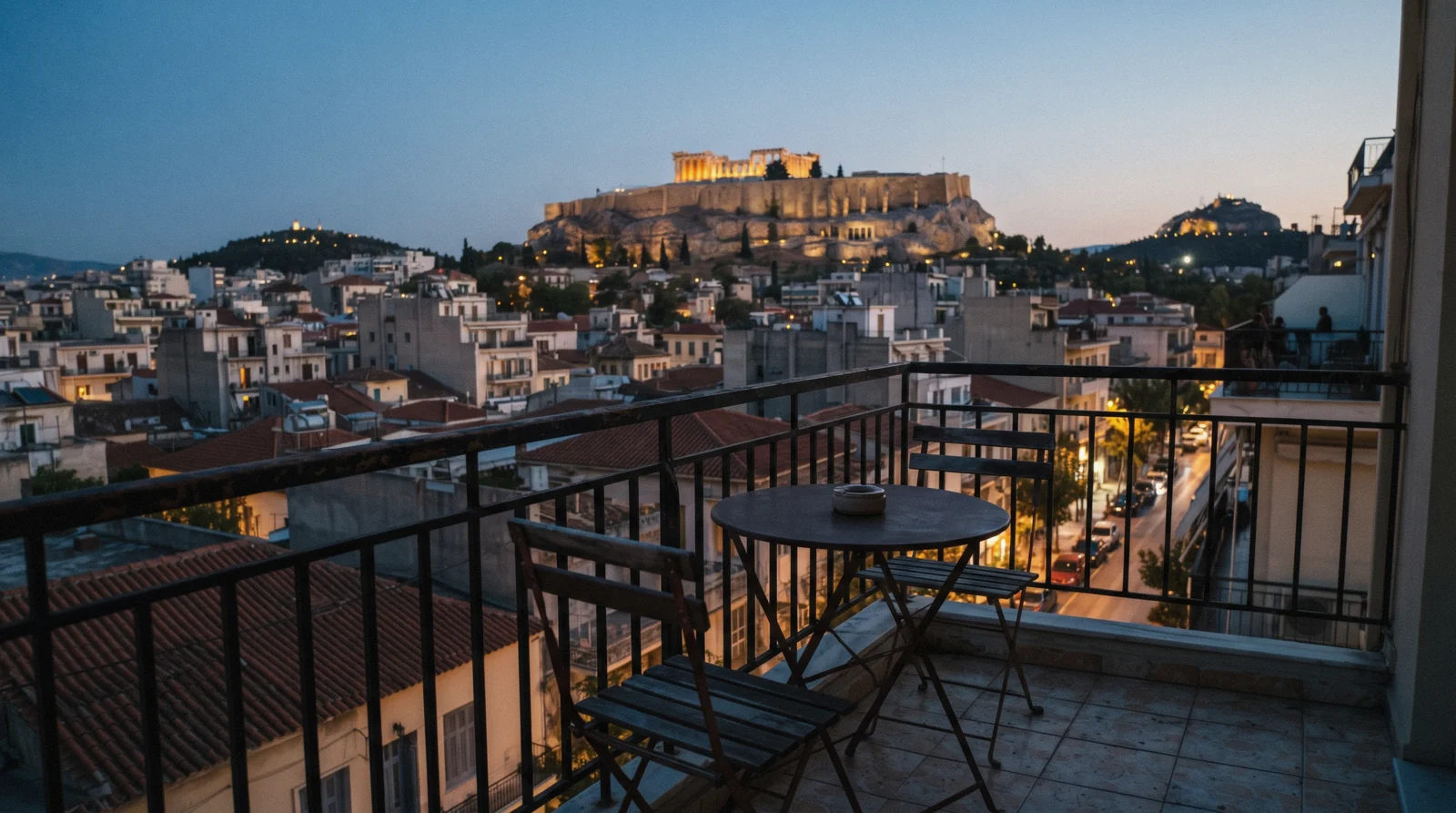 A balcony in central Athens looking towards the lit Acropolis in the evening, where to stay in Athens, Greece